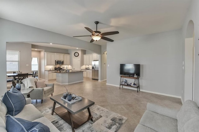 8922 Pinenut Dr, Cypress, TX 77433 - living room featuring arched walkways, a ceiling fan, and light tile patterned floors
