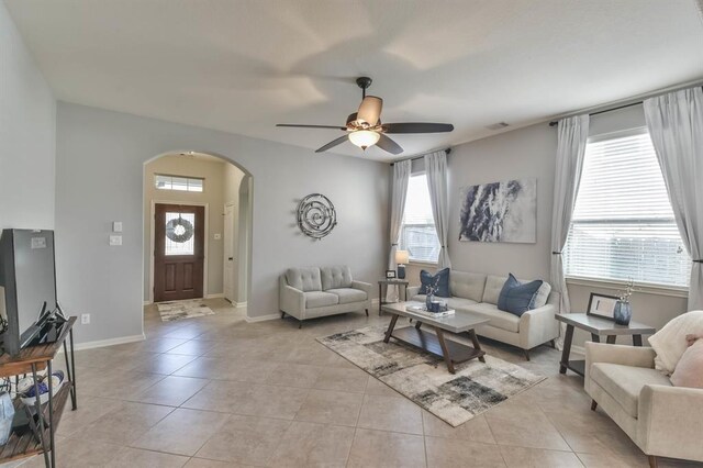8922 Pinenut Dr, Cypress, TX 77433 - living area with arched walkways, ceiling fan, and light tile patterned floors