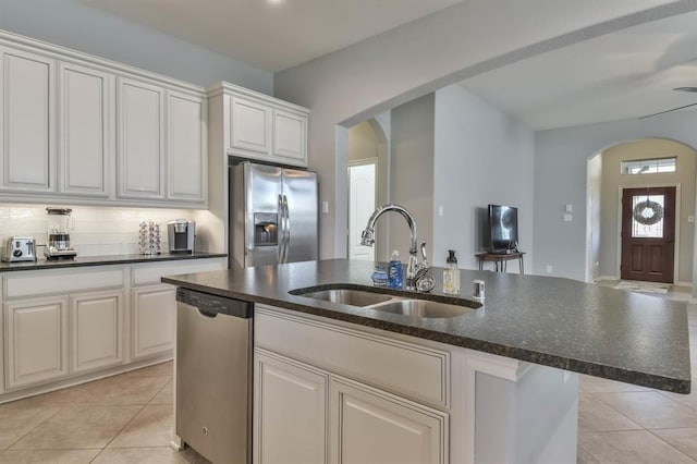 8922 Pinenut Dr, Cypress, TX 77433 - kitchen with appliances with stainless steel finishes, arched walkways, light tile patterned flooring, and an island with sink