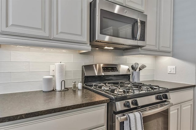 8922 Pinenut Dr, Cypress, TX 77433 - kitchen featuring stainless steel appliances, dark countertops, and decorative backsplash