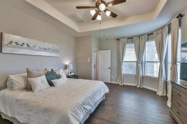 8922 Pinenut Dr, Cypress, TX 77433 - bedroom with a tray ceiling, dark wood-style flooring, and a ceiling fan