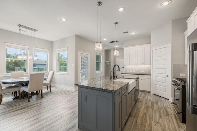 16726 Echo Heights Dr, Cypress, TX 77433 - kitchen featuring high end range, a chandelier, light wood finished floors, tasteful backsplash, and recessed lighting