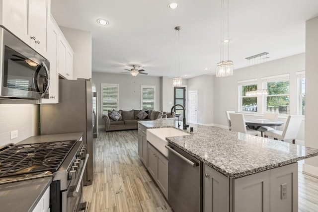 16726 Echo Heights Dr, Cypress, TX 77433 - kitchen with stainless steel appliances, ceiling fan, healthy amount of natural light, a kitchen island with sink, and recessed lighting