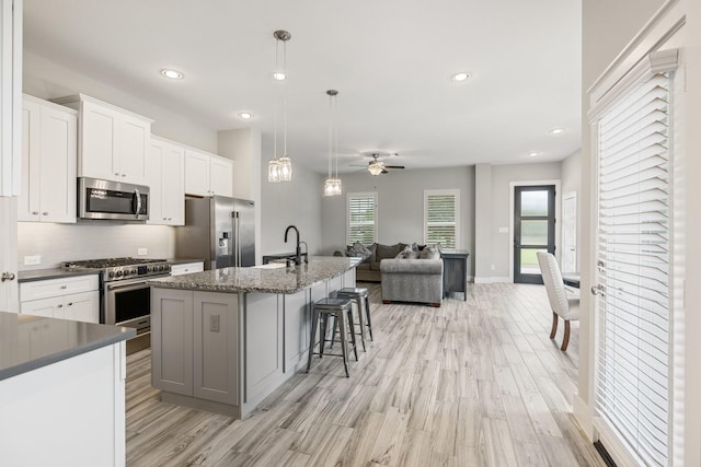 16726 Echo Heights Dr, Cypress, TX 77433 - kitchen with appliances with stainless steel finishes, open floor plan, light wood-style flooring, backsplash, and recessed lighting