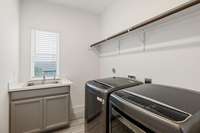 16726 Echo Heights Dr, Cypress, TX 77433 - washroom with independent washer and dryer, cabinet space, and light wood finished floors