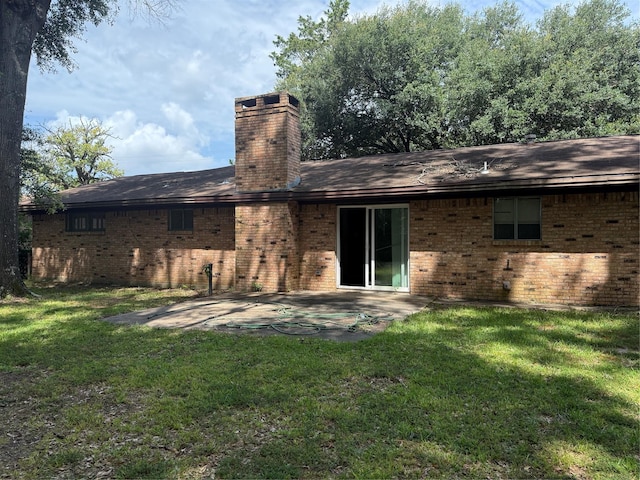 200 Cunningham Dr, Lufkin, TX 75901 - back of property featuring brick siding, a patio area, a chimney, and a lawn