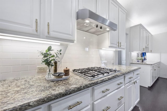 23706 Tristan Bay Ct, Spring, TX 77386 - kitchen featuring under cabinet range hood, stainless steel gas stovetop, white cabinets, and decorative backsplash