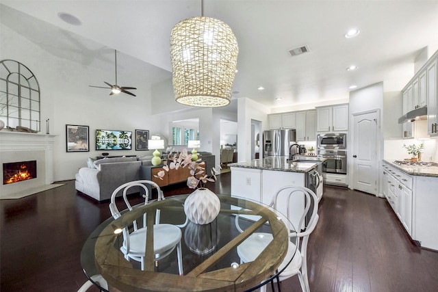 23706 Tristan Bay Ct, Spring, TX 77386 - dining area with dark wood-style flooring, a fireplace with flush hearth, a ceiling fan, and recessed lighting