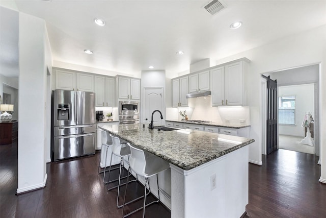 23706 Tristan Bay Ct, Spring, TX 77386 - kitchen featuring appliances with stainless steel finishes, stone counters, decorative backsplash, dark wood-style floors, and recessed lighting