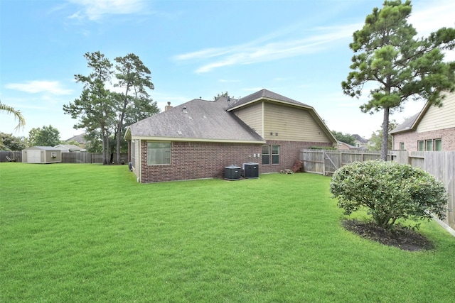 23706 Tristan Bay Ct, Spring, TX 77386 - rear view of house with a fenced backyard, brick siding, a storage unit, and roof with shingles