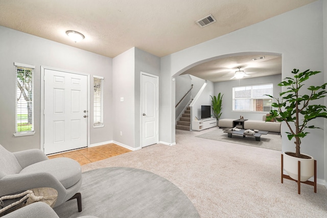 15515 Hinsdale Springs Ln, Houston, TX 77053 - carpeted foyer entrance with arched walkways, stairs, a ceiling fan, and tile patterned floors