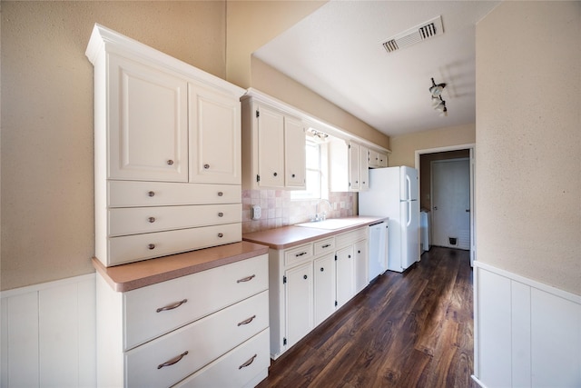 15111 Silverman St, Houston, TX 77598 - kitchen with white appliances, wainscoting, white cabinets, dark wood finished floors, and light countertops