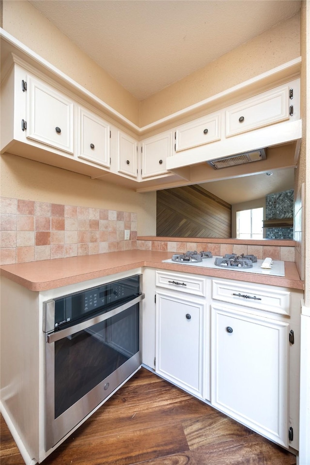 15111 Silverman St, Houston, TX 77598 - kitchen with oven, white gas stovetop, light countertops, white cabinets, and decorative backsplash