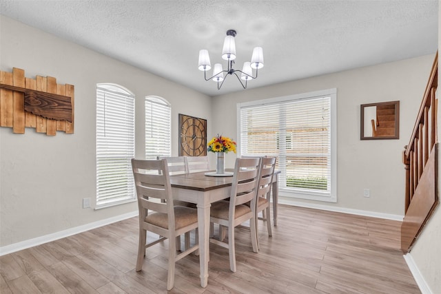 3302 Candlelon Dr, Spring, TX 77388 - dining room featuring a chandelier, light wood-style flooring, a textured ceiling, and stairs