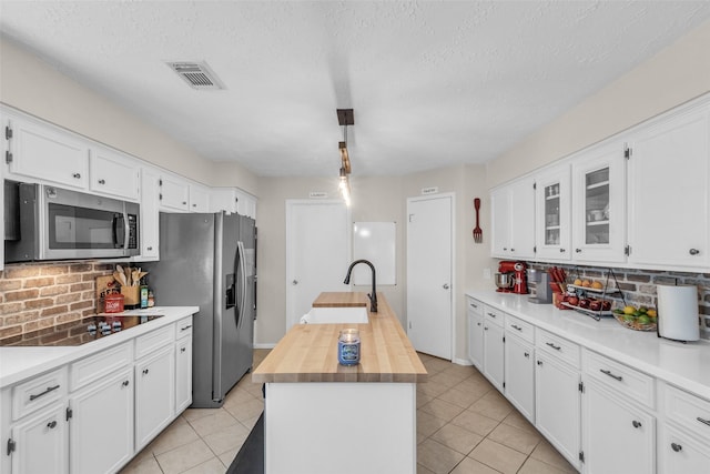 3302 Candlelon Dr, Spring, TX 77388 - kitchen with appliances with stainless steel finishes, decorative backsplash, white cabinetry, wood counters, and a textured ceiling