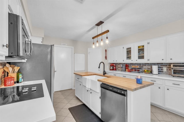 3302 Candlelon Dr, Spring, TX 77388 - kitchen featuring appliances with stainless steel finishes, butcher block counters, tasteful backsplash, and light tile patterned flooring