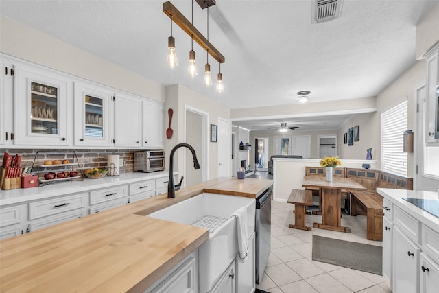 3302 Candlelon Dr, Spring, TX 77388 - kitchen with wood counters, light tile patterned floors, dishwasher, white cabinetry, and open floor plan