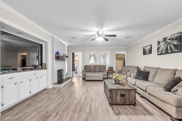 3302 Candlelon Dr, Spring, TX 77388 - living room featuring a stone fireplace, a ceiling fan, light wood finished floors, crown molding, and a textured ceiling
