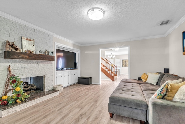 3302 Candlelon Dr, Spring, TX 77388 - living area featuring light wood-style flooring, ornamental molding, a textured ceiling, a chandelier, and a fireplace