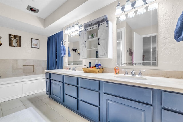 3302 Candlelon Dr, Spring, TX 77388 - bathroom with tile patterned floors, double vanity, a bath, and a textured wall
