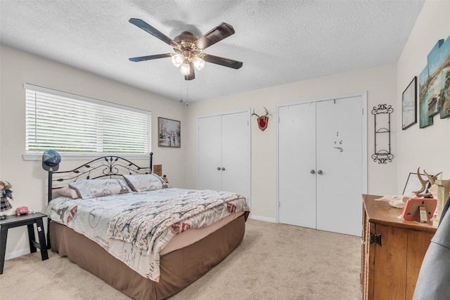 3302 Candlelon Dr, Spring, TX 77388 - bedroom with multiple closets, light colored carpet, a textured ceiling, and a ceiling fan