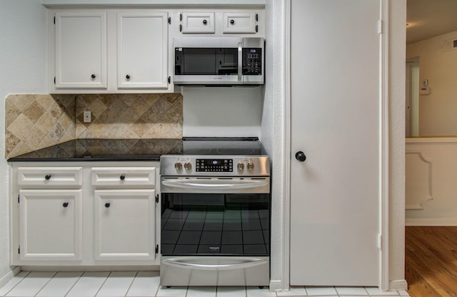 5711 Sugar Hill Dr Unit 108, Houston, TX 77057 - kitchen featuring stainless steel appliances, dark countertops, white cabinetry, decorative backsplash, and light wood-style floors