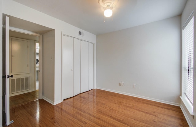 5711 Sugar Hill Dr Unit 108, Houston, TX 77057 - unfurnished bedroom with wood finished floors, multiple windows, a closet, and ceiling fan