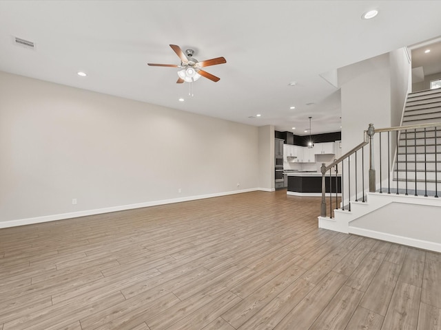 1109 Robbie St, Houston, TX 77009 - unfurnished living room featuring a ceiling fan, light wood finished floors, stairway, and recessed lighting
