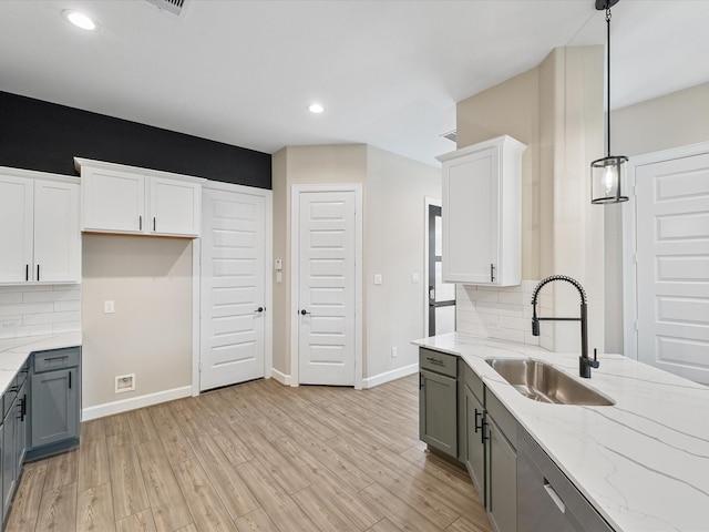 1109 Robbie St, Houston, TX 77009 - kitchen featuring backsplash, light stone countertops, gray cabinetry, and recessed lighting
