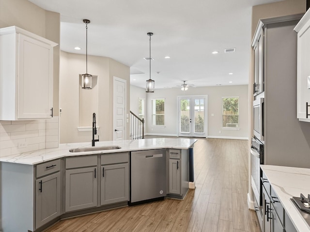 1109 Robbie St, Houston, TX 77009 - kitchen with stainless steel appliances, gray cabinetry, a ceiling fan, open floor plan, and recessed lighting
