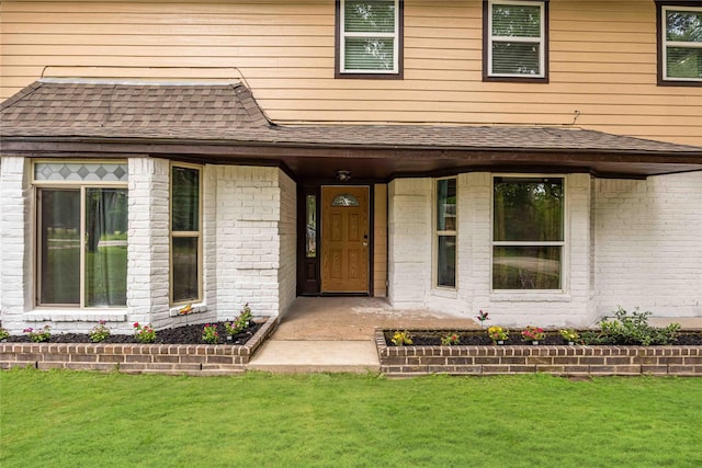 478 Brandon Rd, Conroe, TX 77302 - property entrance featuring a lawn, roof with shingles, and brick siding