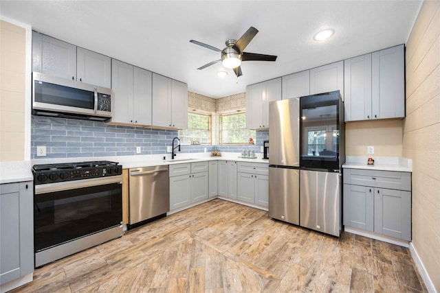 478 Brandon Rd, Conroe, TX 77302 - kitchen with stainless steel appliances, gray cabinetry, tasteful backsplash, ceiling fan, and light countertops