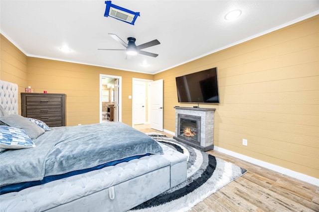 478 Brandon Rd, Conroe, TX 77302 - bedroom featuring ornamental molding, wood finished floors, wood walls, a glass covered fireplace, and recessed lighting