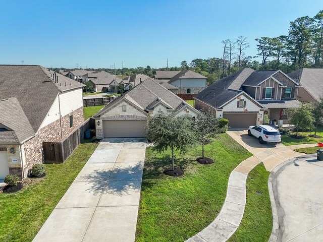 14510 Kasey Flowers Ct, Humble, TX 77396 - view of front of house featuring a residential view, concrete driveway, an attached garage, and a front lawn