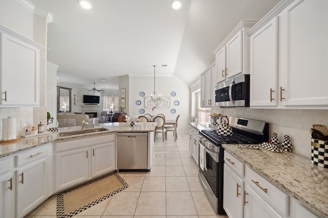14510 Kasey Flowers Ct, Humble, TX 77396 - kitchen with stainless steel appliances, backsplash, white cabinetry, recessed lighting, and vaulted ceiling