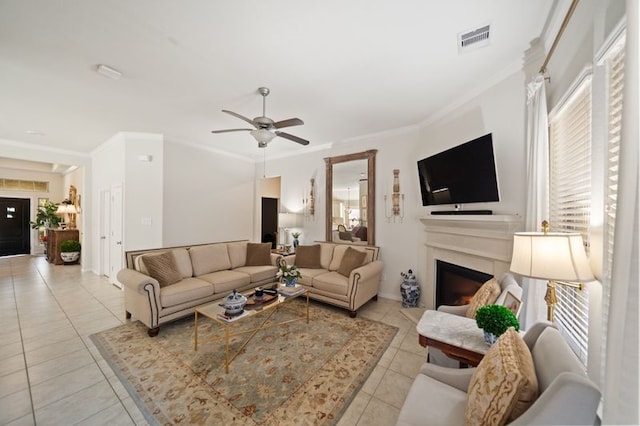 14510 Kasey Flowers Ct, Humble, TX 77396 - living area featuring light tile patterned flooring, a fireplace, ceiling fan, ornamental molding, and healthy amount of natural light