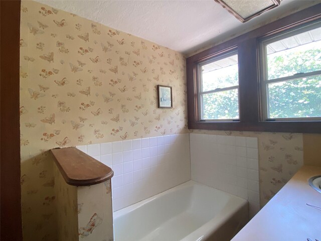 222 N 1st, Wallis, TX 77485 - full bathroom with wallpapered walls, a garden tub, and a textured ceiling