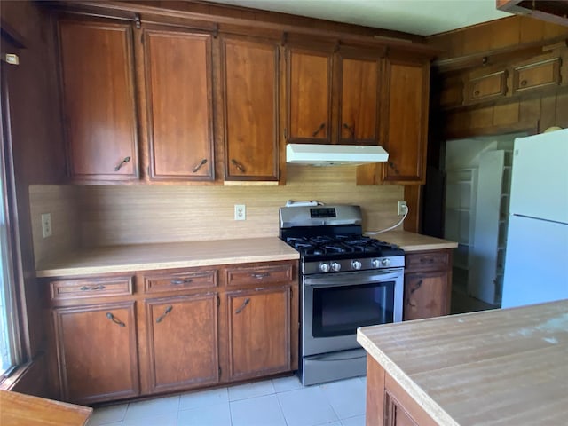 222 N 1st, Wallis, TX 77485 - kitchen with stainless steel range with gas cooktop, under cabinet range hood, freestanding refrigerator, and light countertops