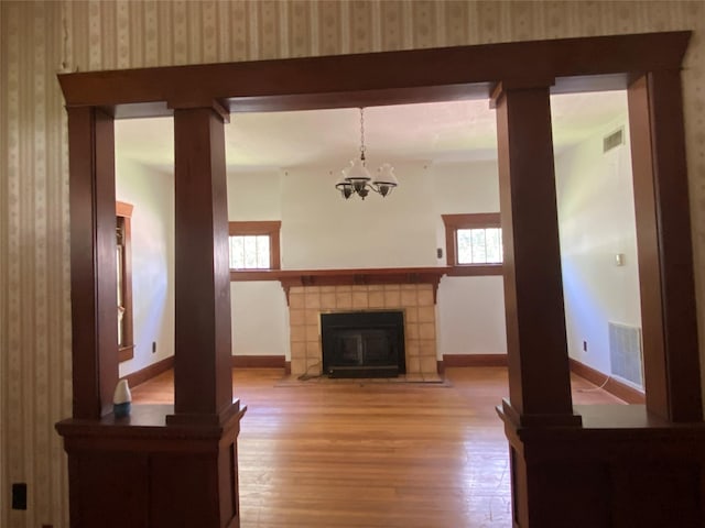 222 N 1st, Wallis, TX 77485 - unfurnished living room with light wood-style floors, healthy amount of natural light, a chandelier, and wallpapered walls