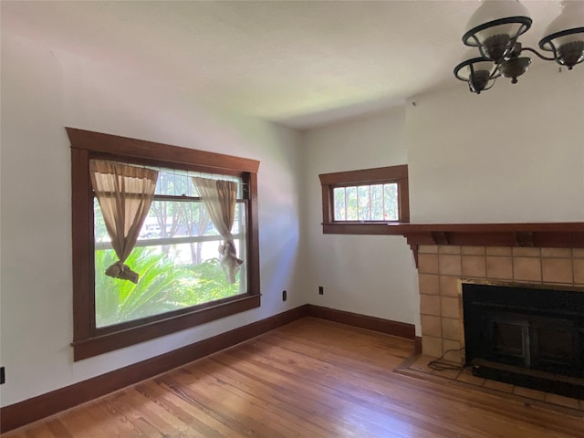 222 N 1st, Wallis, TX 77485 - unfurnished living room with a chandelier, wood finished floors, and a tile fireplace
