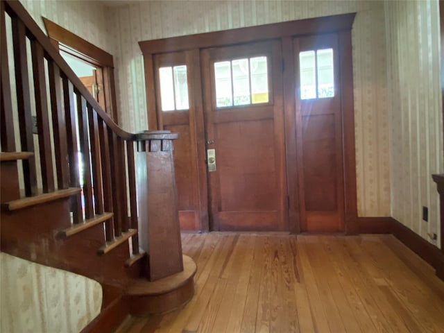 222 N 1st, Wallis, TX 77485 - foyer entrance with wallpapered walls, light wood-style floors, healthy amount of natural light, and stairway