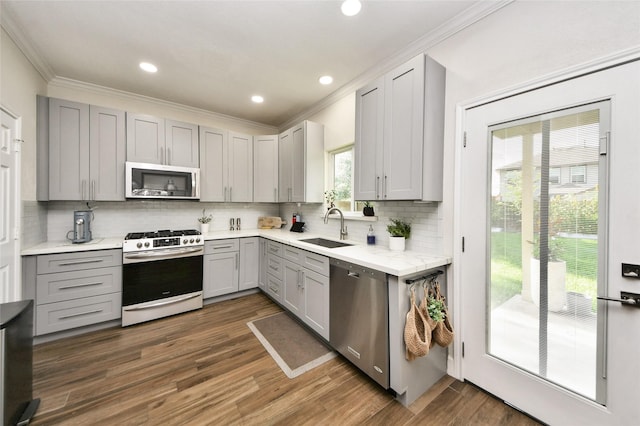2014 Fisher Trace Ct, Spring, TX 77373 - kitchen with appliances with stainless steel finishes, gray cabinetry, ornamental molding, decorative backsplash, and dark wood-style flooring