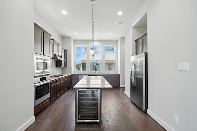151 E 2nd St, Houston, TX 77007 - kitchen featuring wine cooler, appliances with stainless steel finishes, under cabinet range hood, a kitchen island, and backsplash