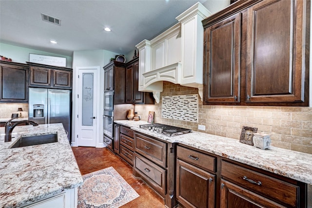 3403 Westhaven Ct, Fulshear, TX 77441 - kitchen featuring stainless steel appliances, dark brown cabinets, backsplash, light stone counters, and recessed lighting