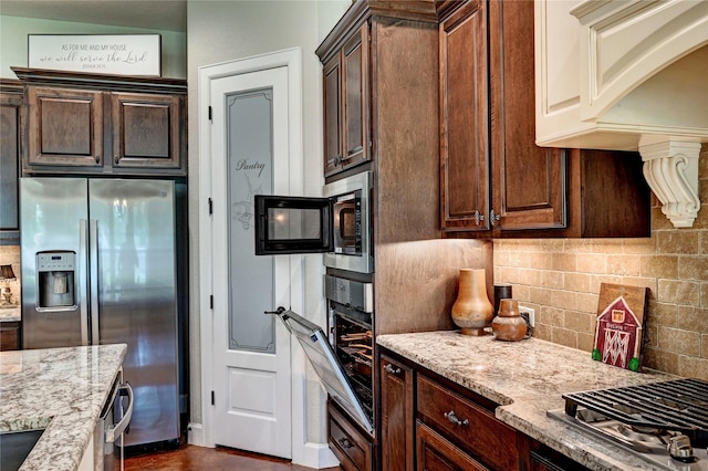 3403 Westhaven Ct, Fulshear, TX 77441 - kitchen with stainless steel appliances, light stone countertops, tasteful backsplash, and dark brown cabinetry