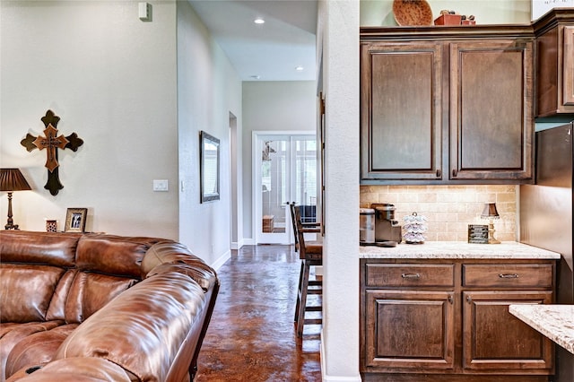 3403 Westhaven Ct, Fulshear, TX 77441 - kitchen with tasteful backsplash, open floor plan, dark brown cabinets, recessed lighting, and light stone countertops
