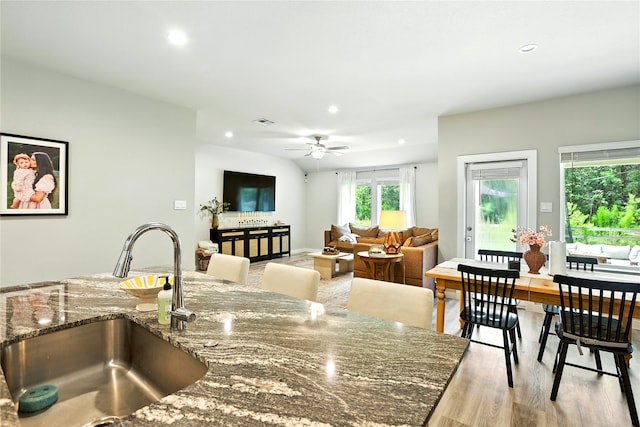 621 Little Spring Ct, Anahuac, TX 77514 - kitchen with wood finished floors, recessed lighting, dark stone countertops, and a ceiling fan