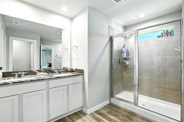 621 Little Spring Ct, Anahuac, TX 77514 - bathroom featuring a stall shower, double vanity, and wood finished floors
