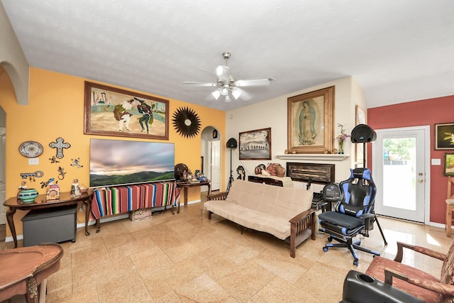 7807 Board Xing, Conroe, TX 77304 - living room with arched walkways, a ceiling fan, and a fireplace