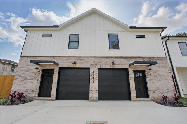 4719 Mallow St, Houston, TX 77033 - view of front of home with brick siding, board and batten siding, concrete driveway, and an attached garage
